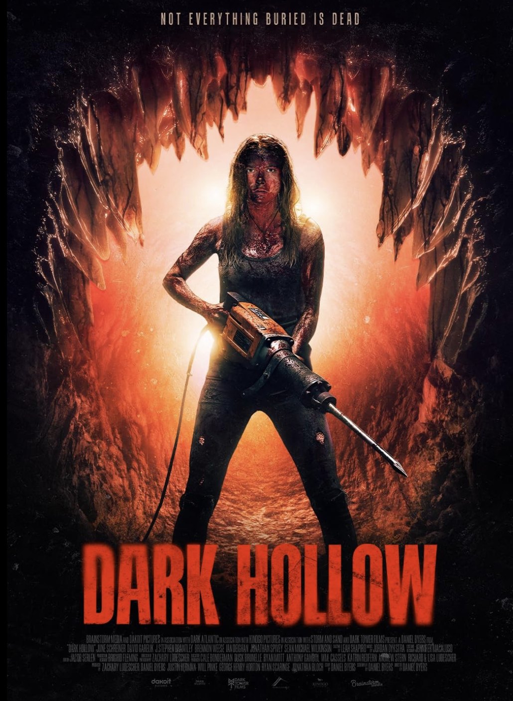 Dark Hollow poster: a blood-streaked woman holding a jackhammer at the mouth of a mine. Not everything buried is dead.